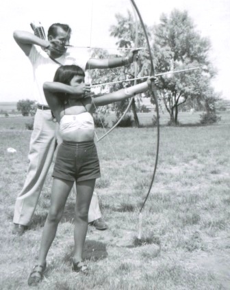 Gaye Lyn Gravely with her dad, Saunie, learning to shoot archery.