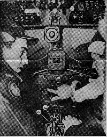1945 photo of Captain Robert Montanarella seat to the left of Copilot Harold Chaplain discussing aircraft instrument panel in background.
