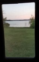 Pink-tinged sky and surface of Lake Lewisville thru window in Gracie, Gaye Lyn's RV. Camping at Hickory Creek, TX.