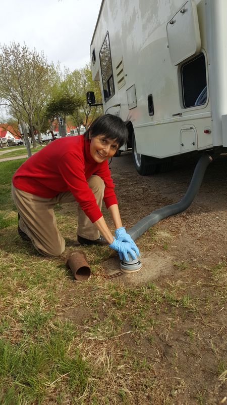 Duties calls, so to speak. Gaye Lyn performs one of the more exacting functions of being an RV owner - emptying the potty via a 10' hose into a sewer outlet.
